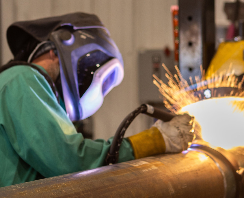 Person Welding On Metal Pipe